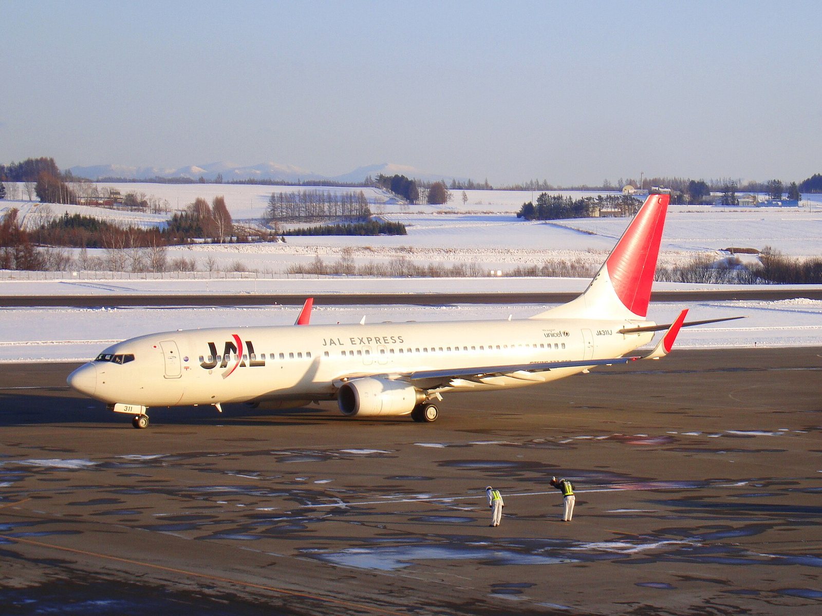 雪景色の女満別空港でタキシングするJALのボーイング737