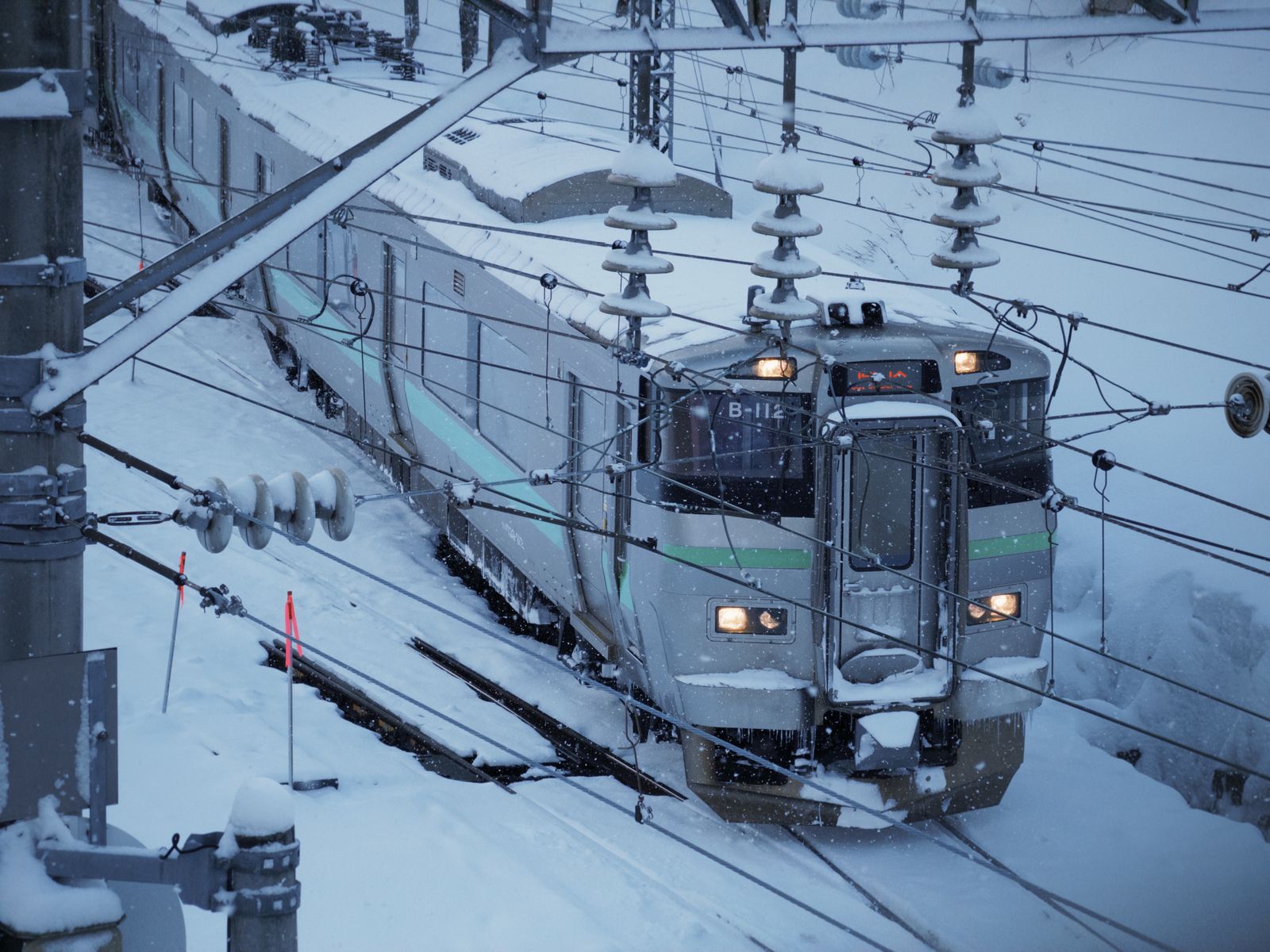 大雪の線路を走るJR北海道の普通列車