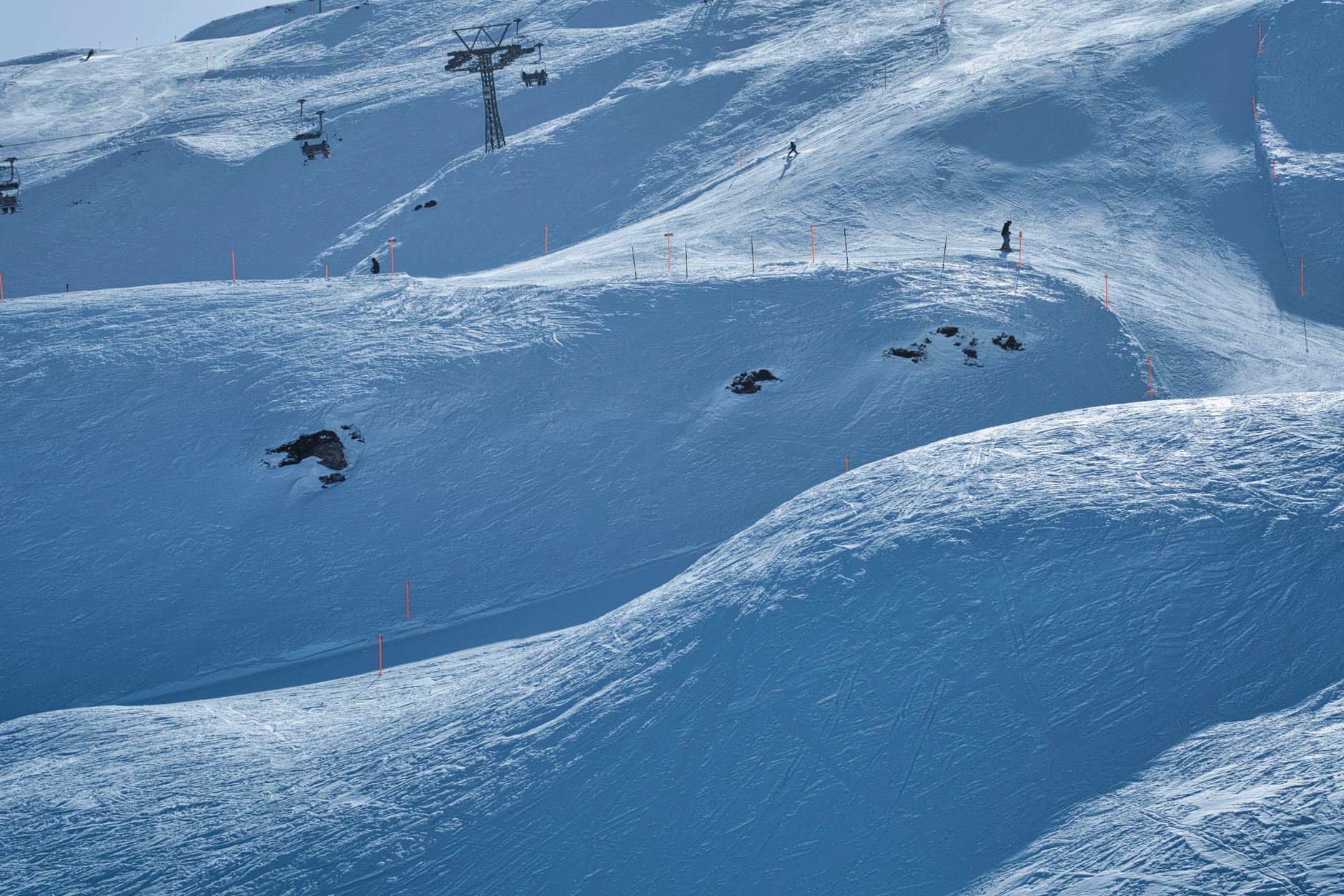 リフトが架かる雪山のゲレンデを滑るスキーヤー(イメージ)