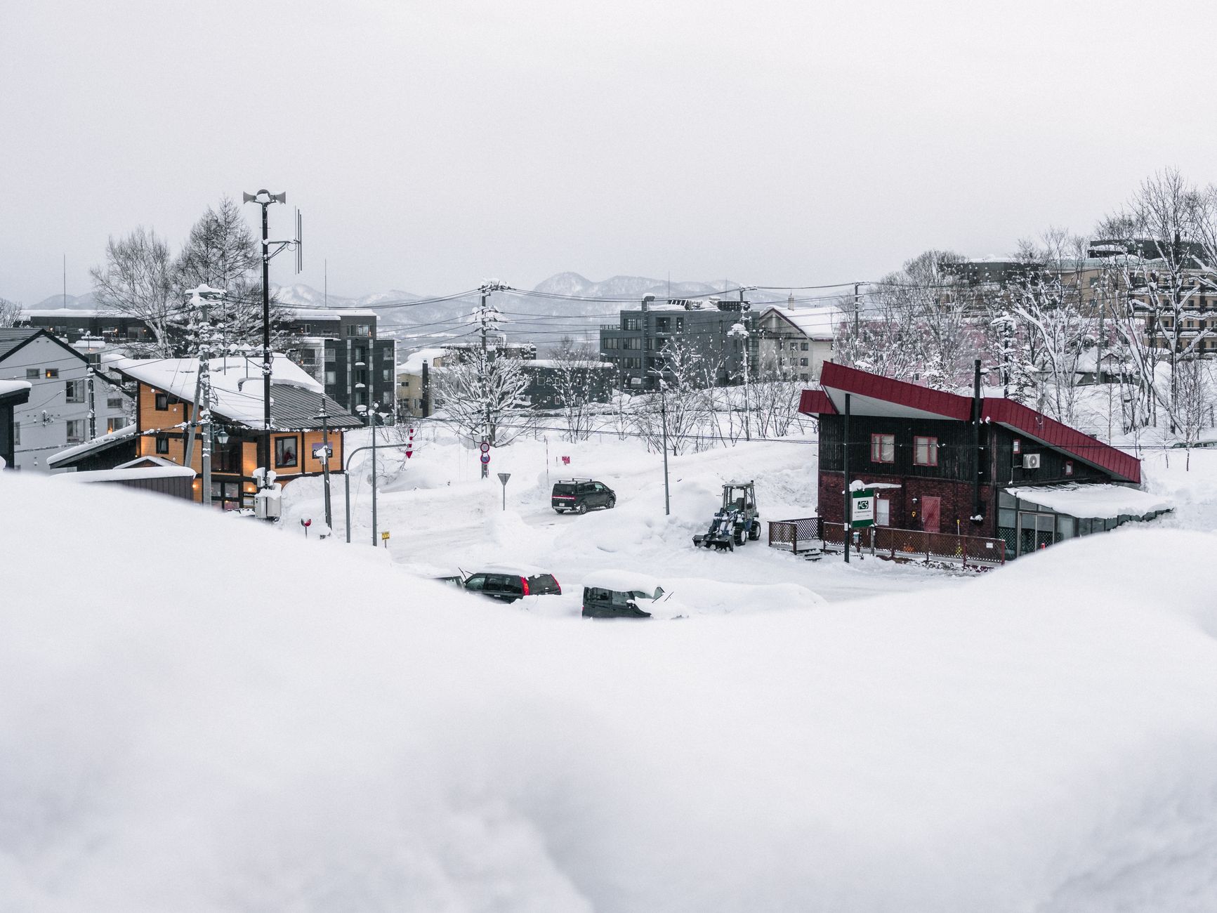深い雪に埋もれたニセコの街並みと遠くに見える山々