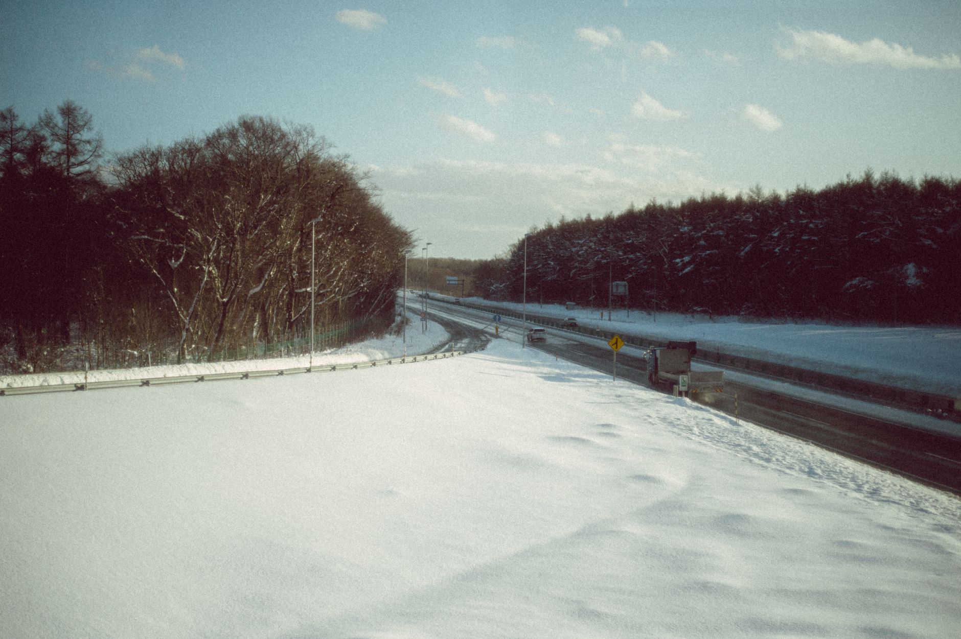 路肩まで雪に覆われた冬の北海道の幹線道路