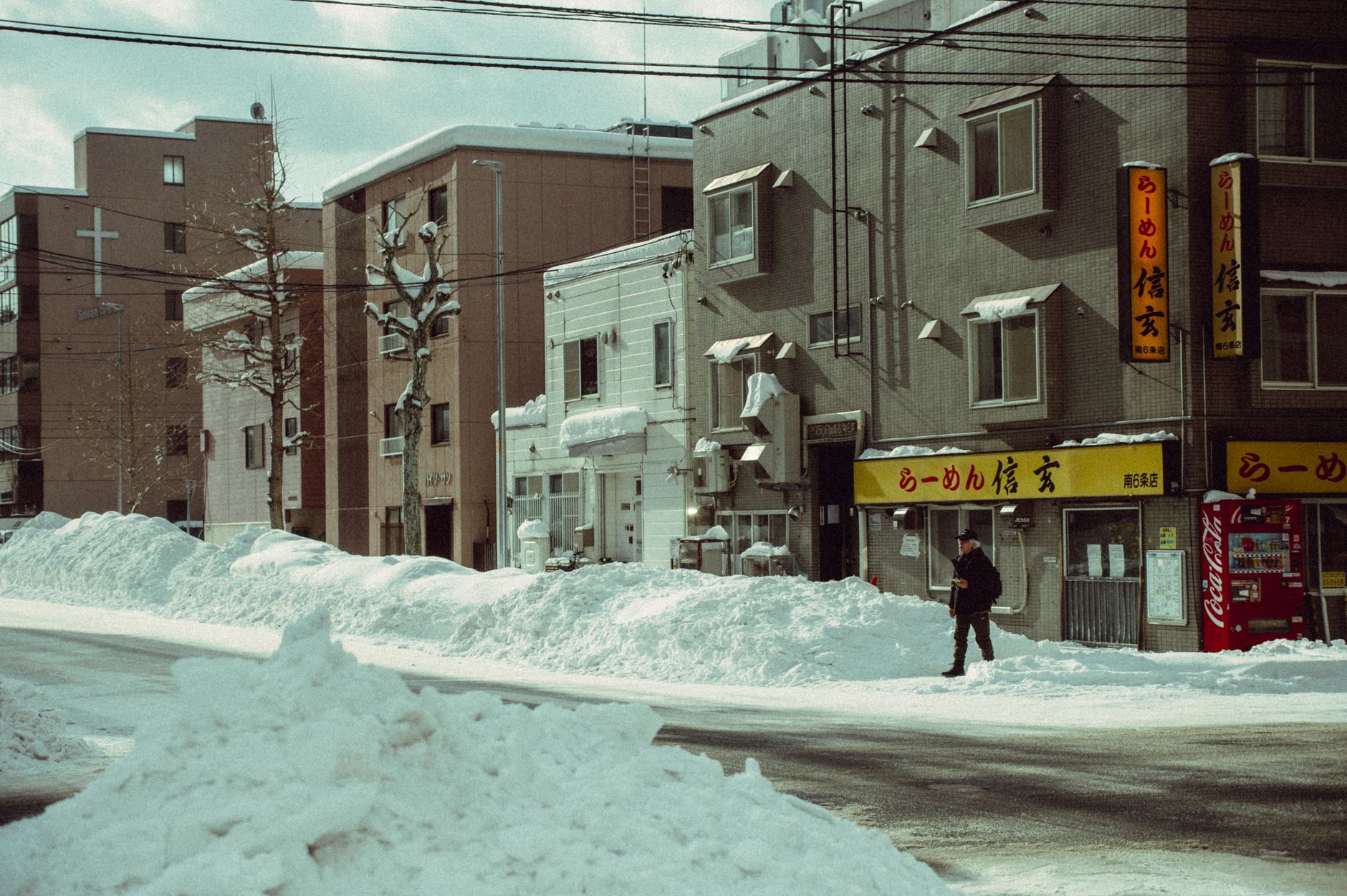 除雪した雪が歩道脇に高く積み上がった冬の札幌の街角