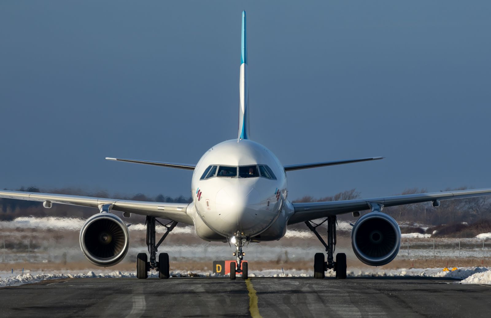 雪の残る空港の誘導路を走行する旅客機(イメージ)