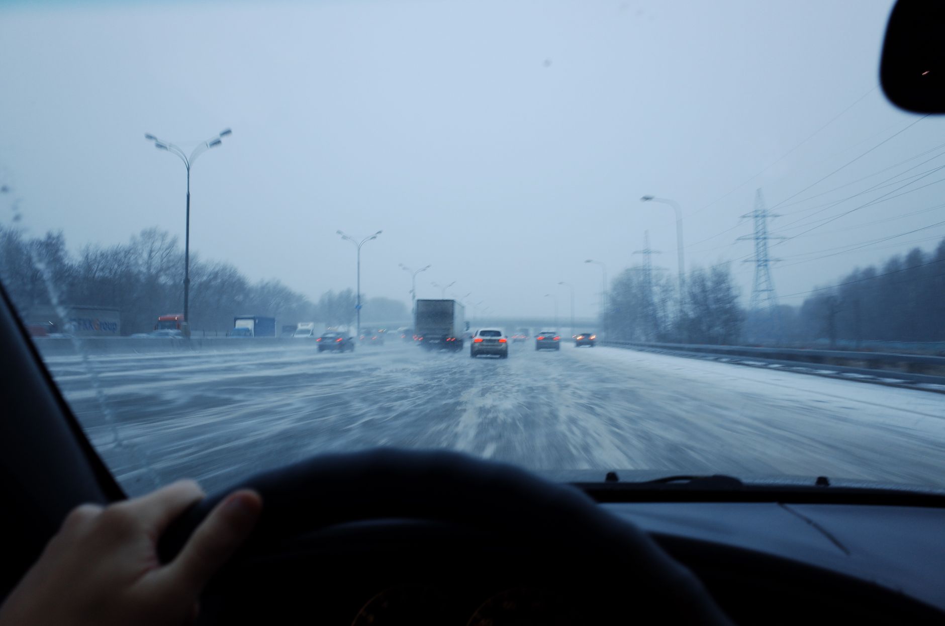 運転席から見た雪道と前を走る車。車間距離を大きく取っている(イメージ)