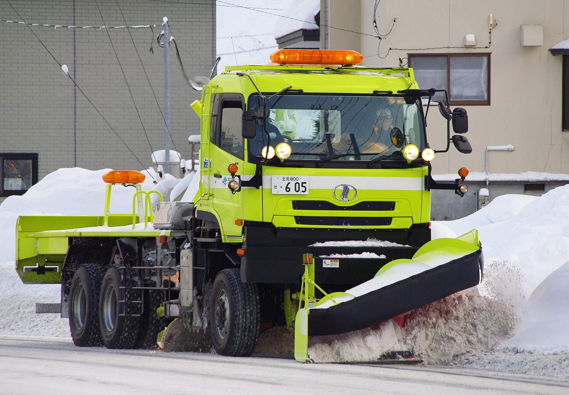 羽根の付いた除雪トラックが市街地の雪を押しのけて進む(網走市)