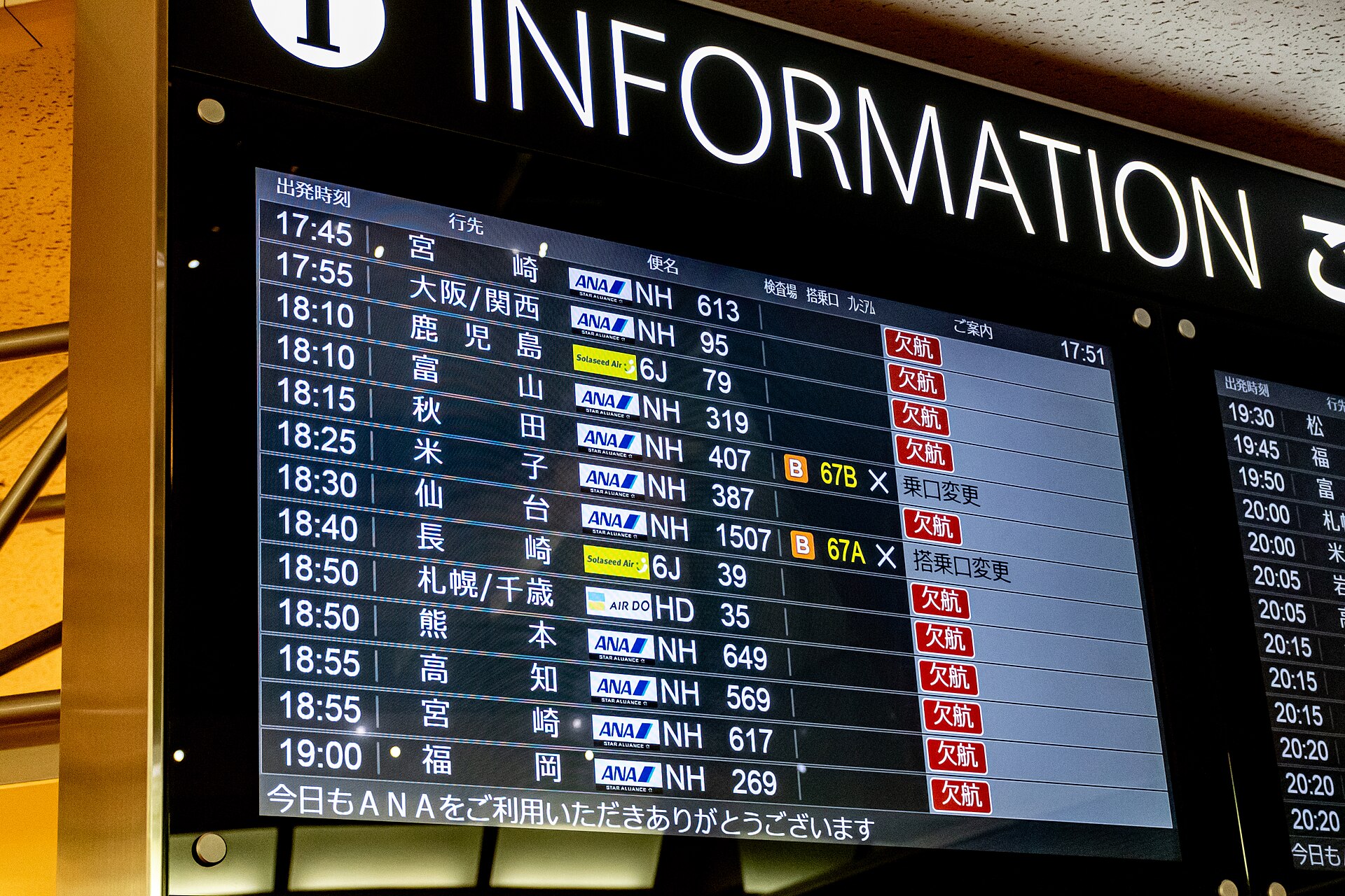 空港の出発案内表示に並ぶ便名と出発時刻
