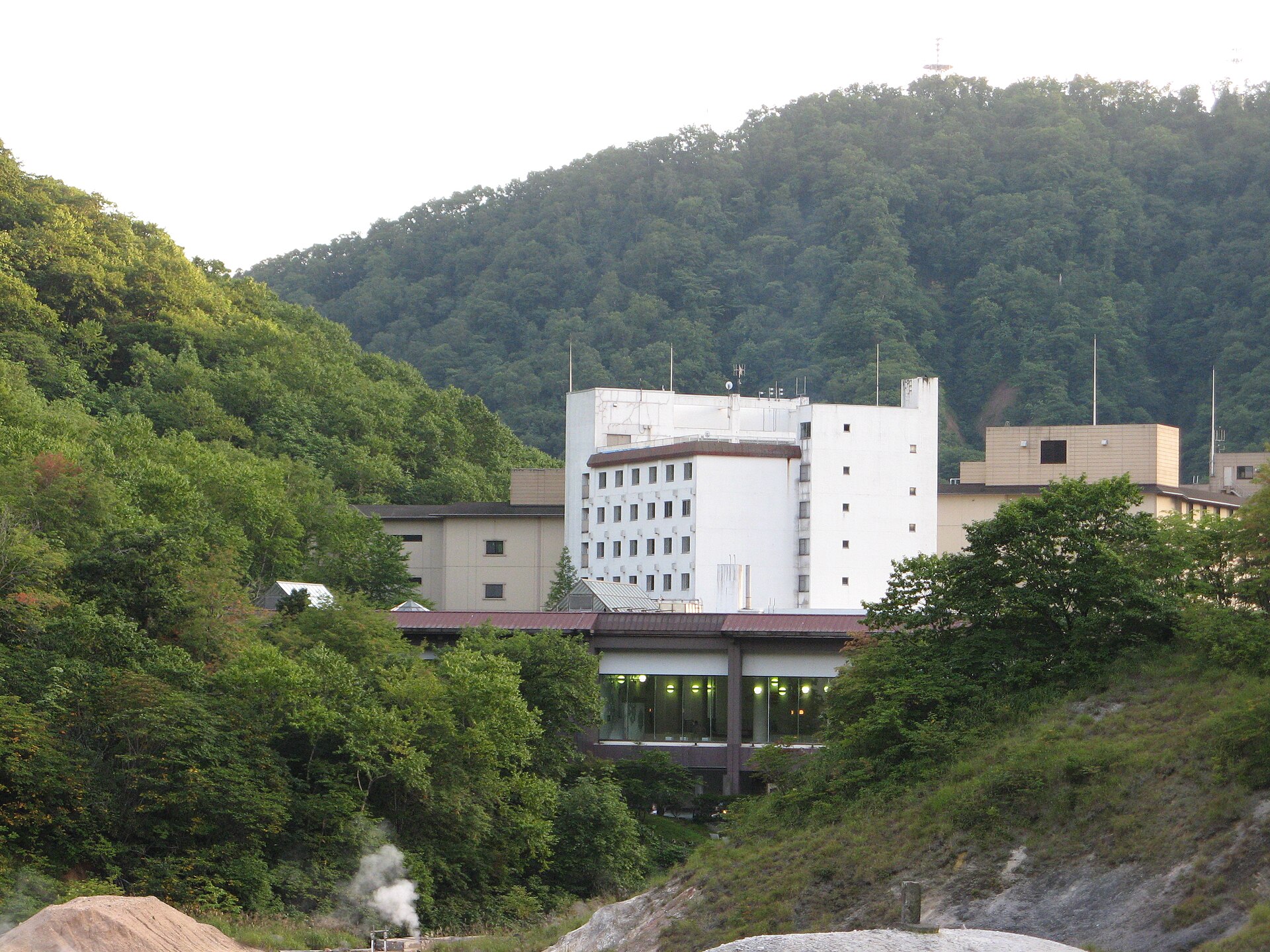 地獄谷側から見た第一滝本館の建物と手前に上がる噴気