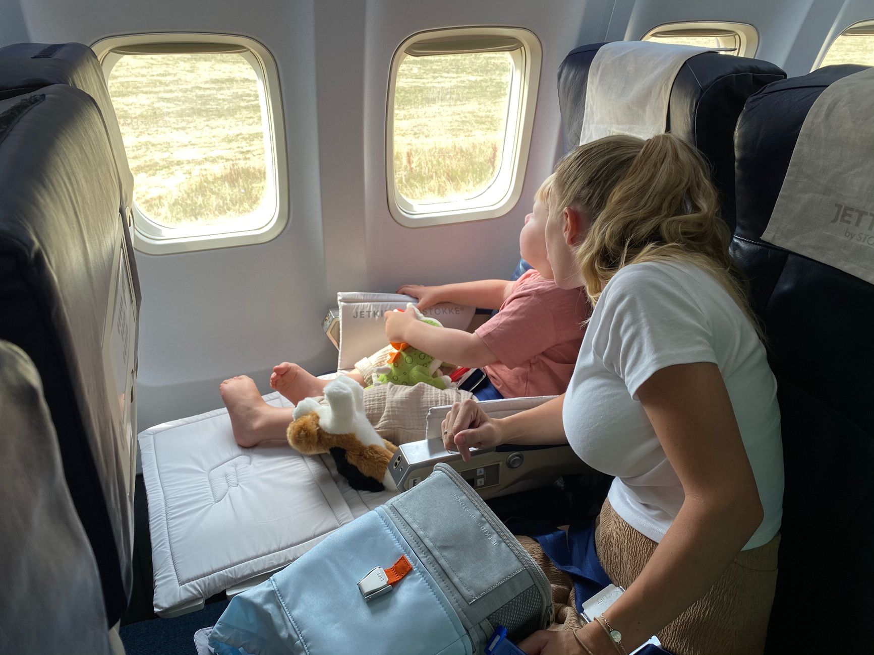 飛行機の窓側席に座る親子(イメージ)