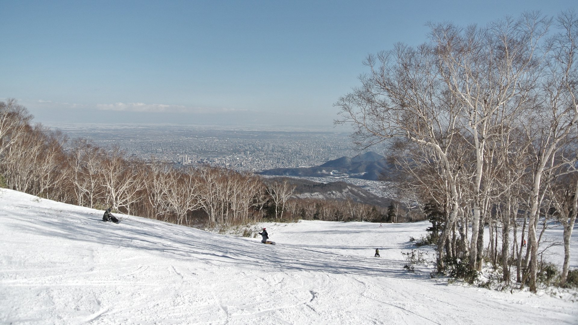 12月初旬のサッポロテイネのゲレンデと白樺の木、遠くに広がる平野