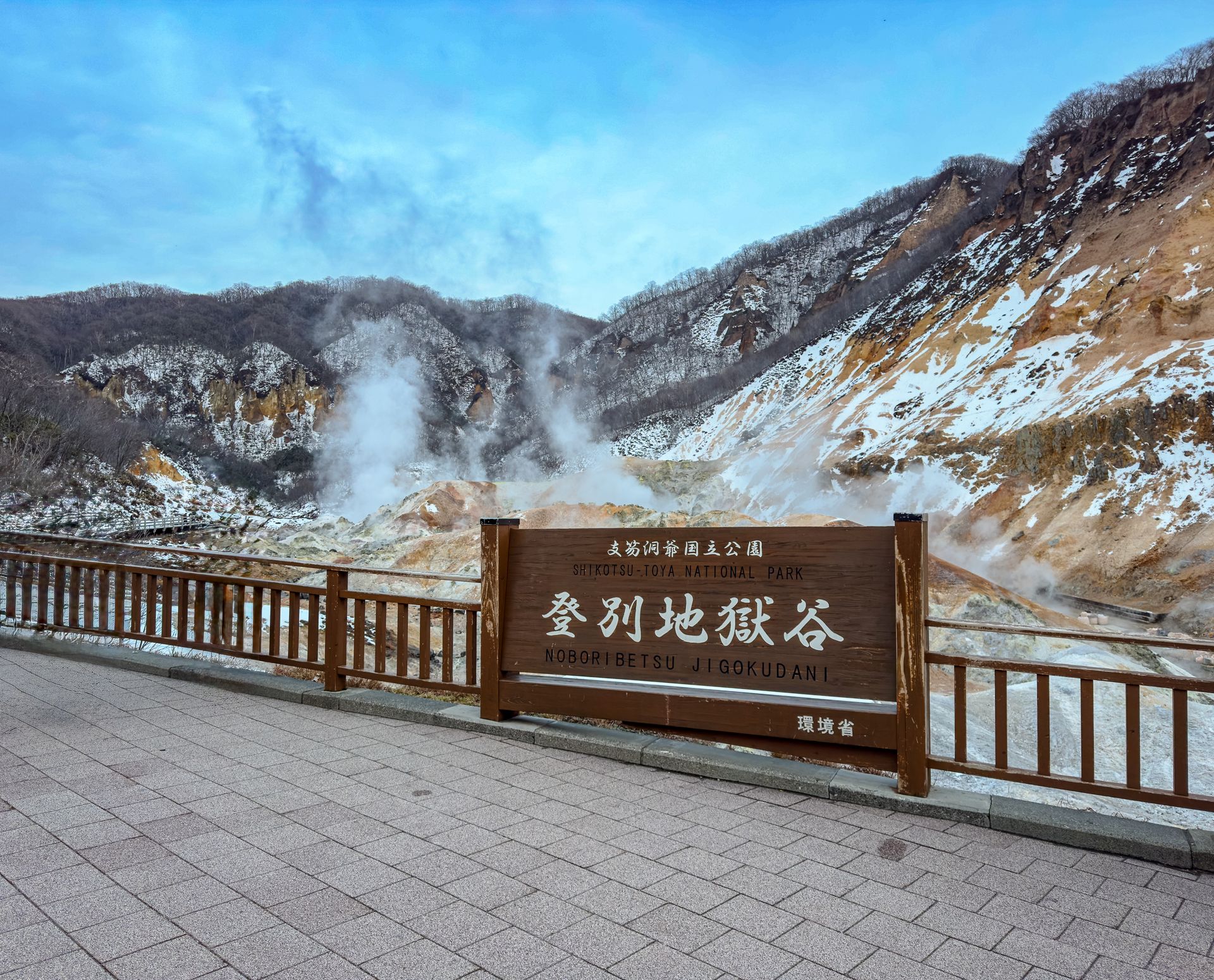 雪が残る登別地獄谷と展望台の「登別地獄谷」看板