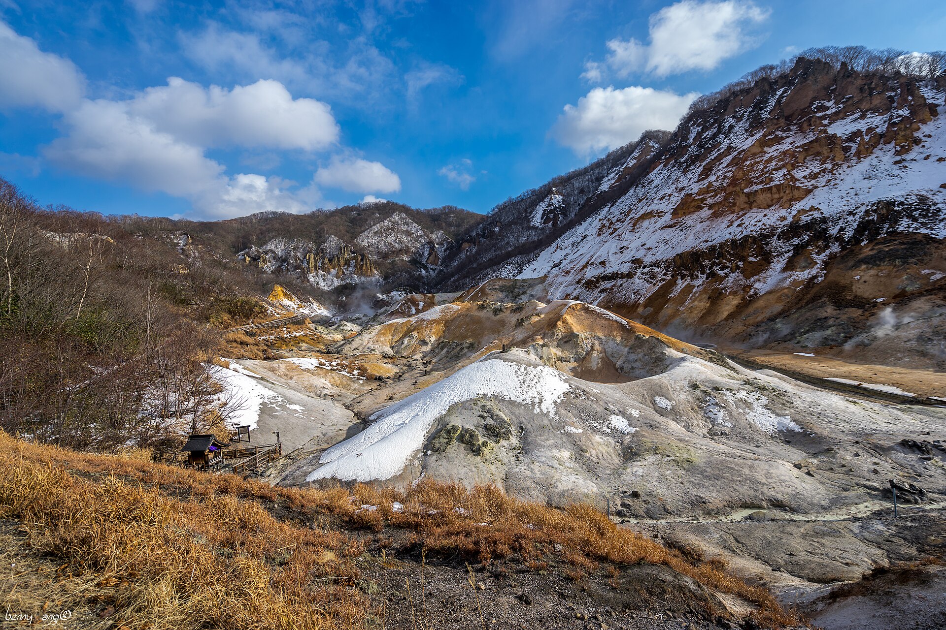 12月の登別地獄谷。斜面に雪が積もり、谷底から噴気が上がる