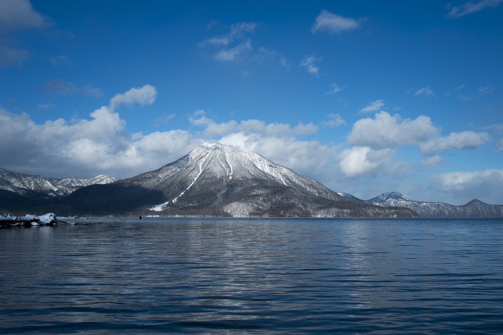 雪をかぶった山と青い湖面が広がる冬の支笏湖
