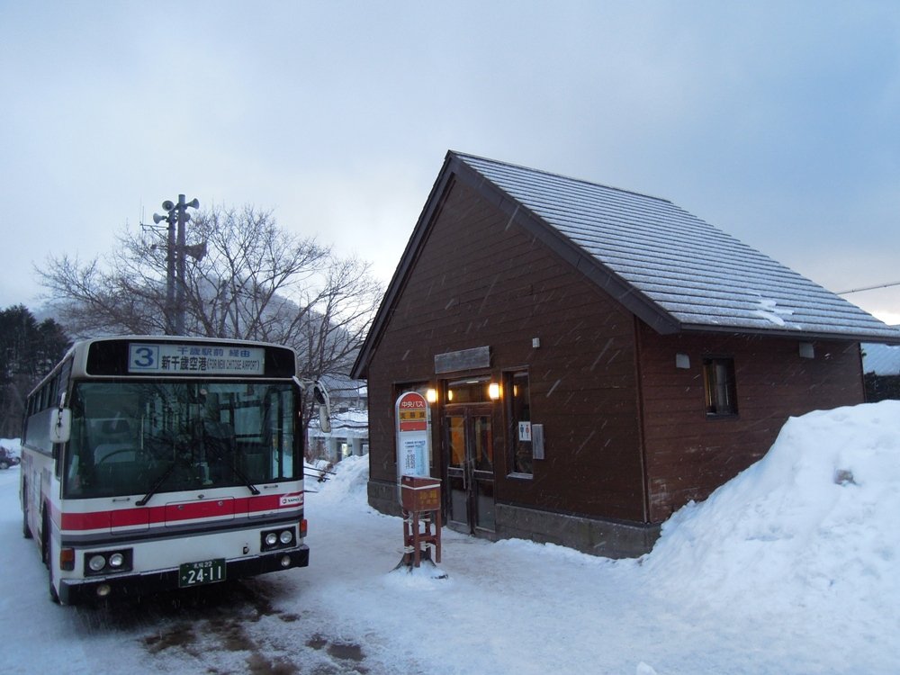 雪の積もった支笏湖バス停の待合所と、新千歳空港行きの北海道中央バス