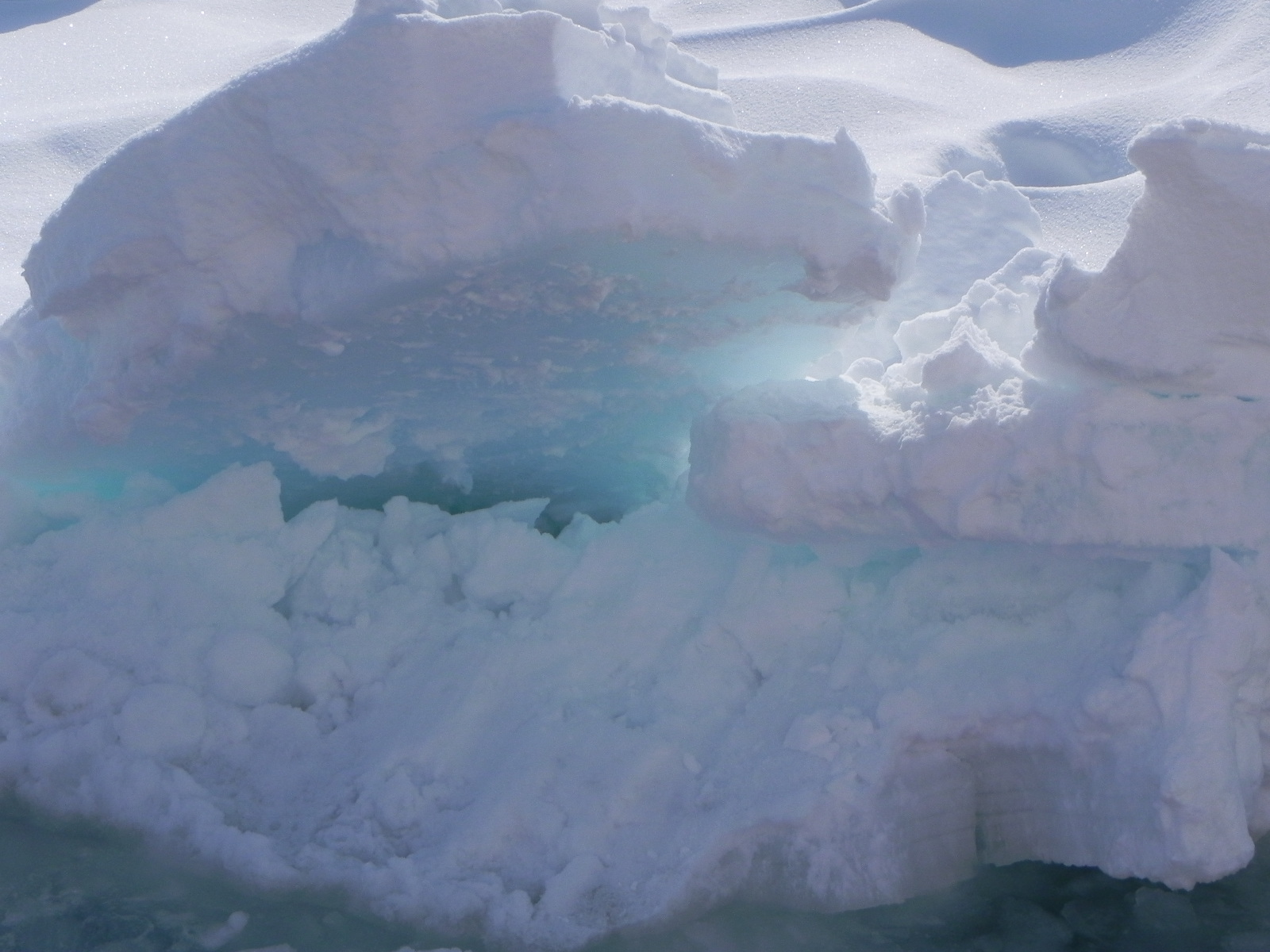 積み重なった流氷の断面。雪の下の氷が青緑色に透けて見える