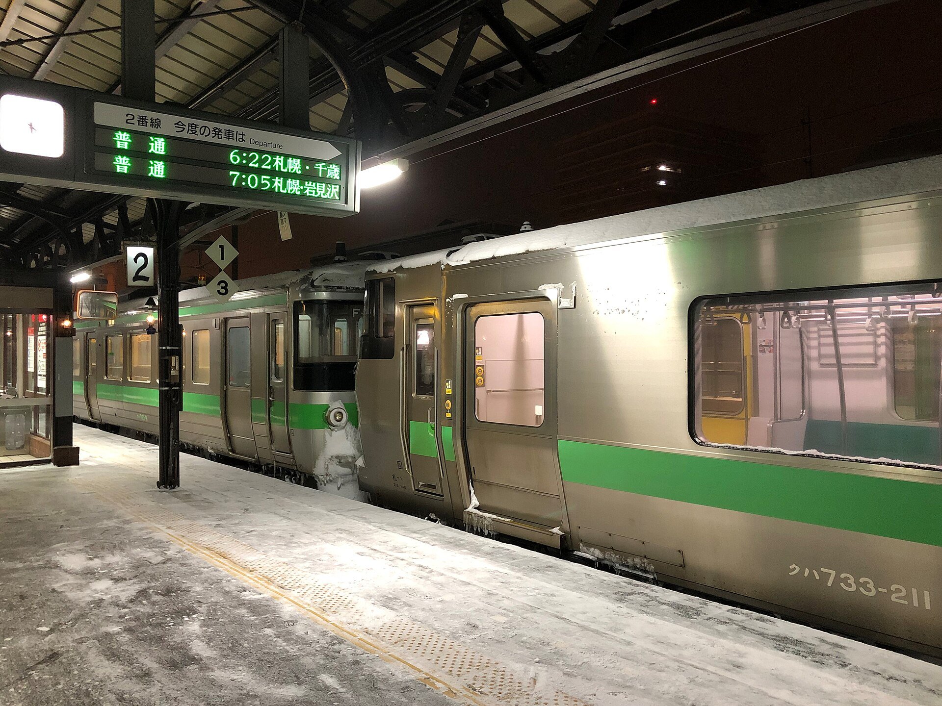 雪の小樽駅ホームに停車するJR北海道の普通列車(733系と721系の併結・札幌方面行き)
