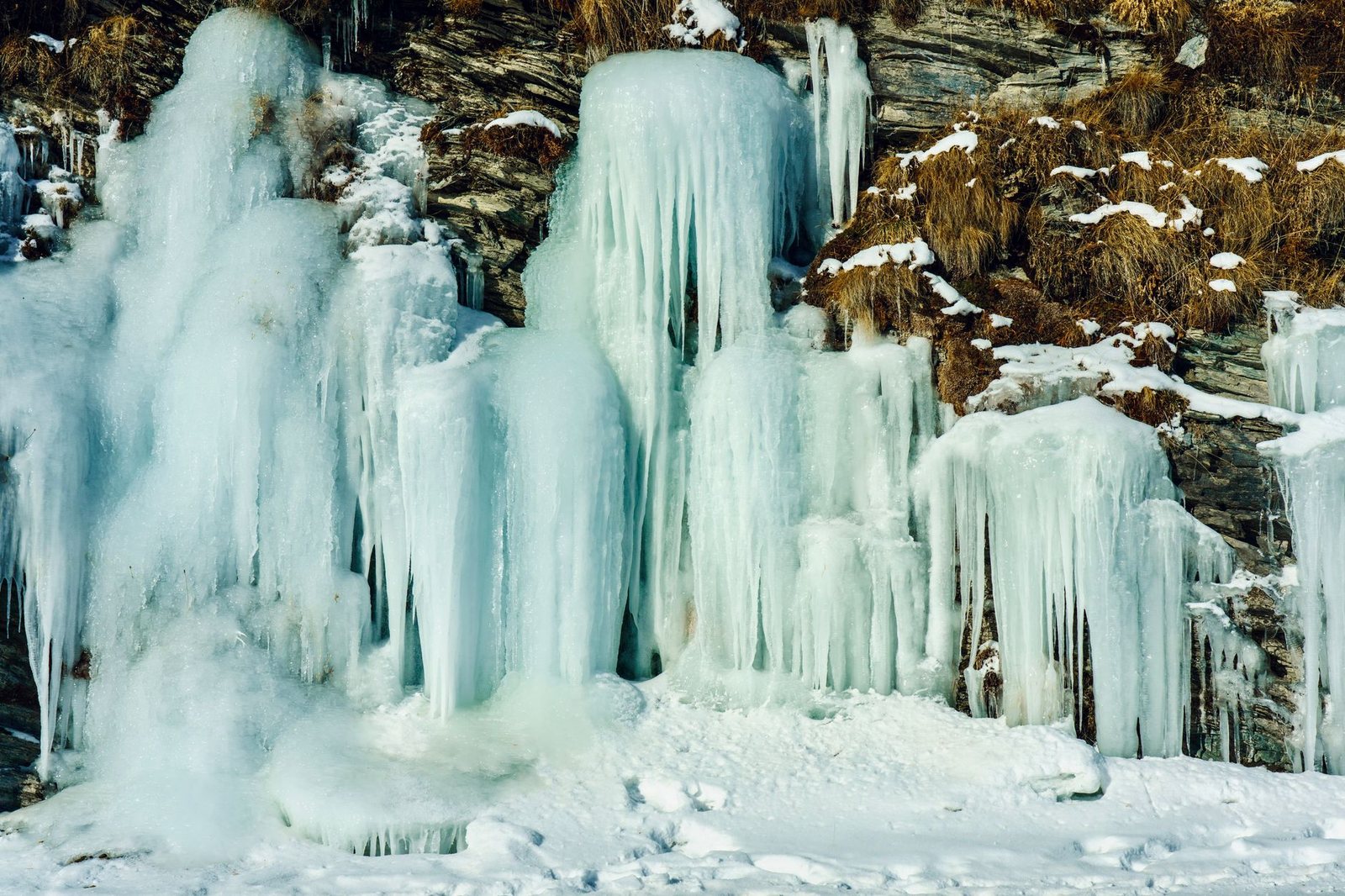 岩壁一面に垂れ下がる大きな氷柱と凍りついた滝（イメージ）