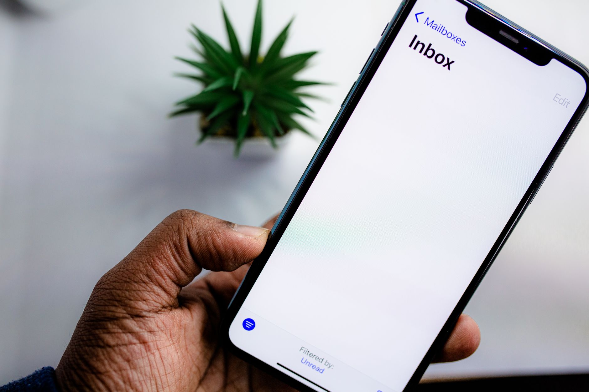 スマートフォンでメールの受信箱を確認する手元（イメージ）