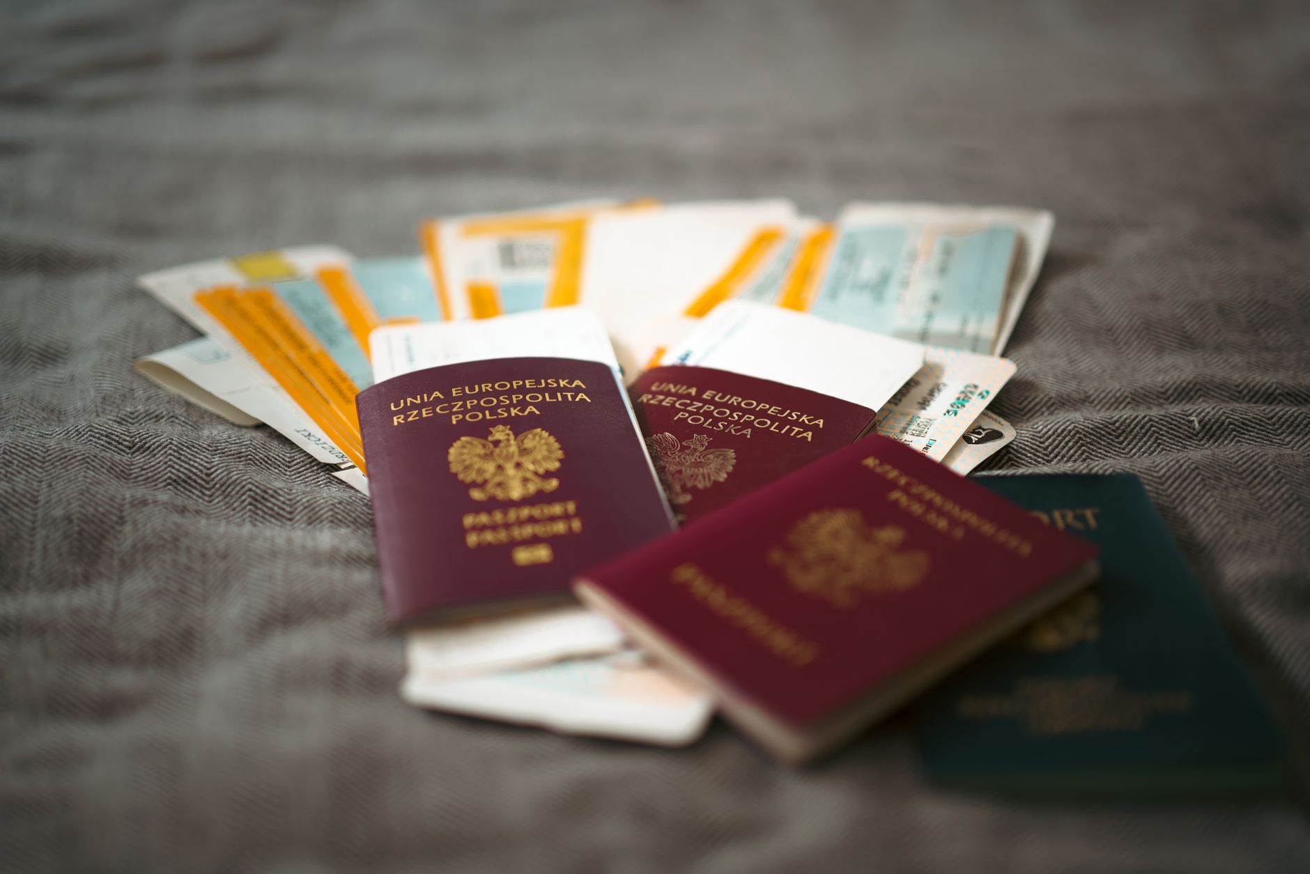 テーブルに広げたパスポートと航空券などの旅行書類(イメージ)