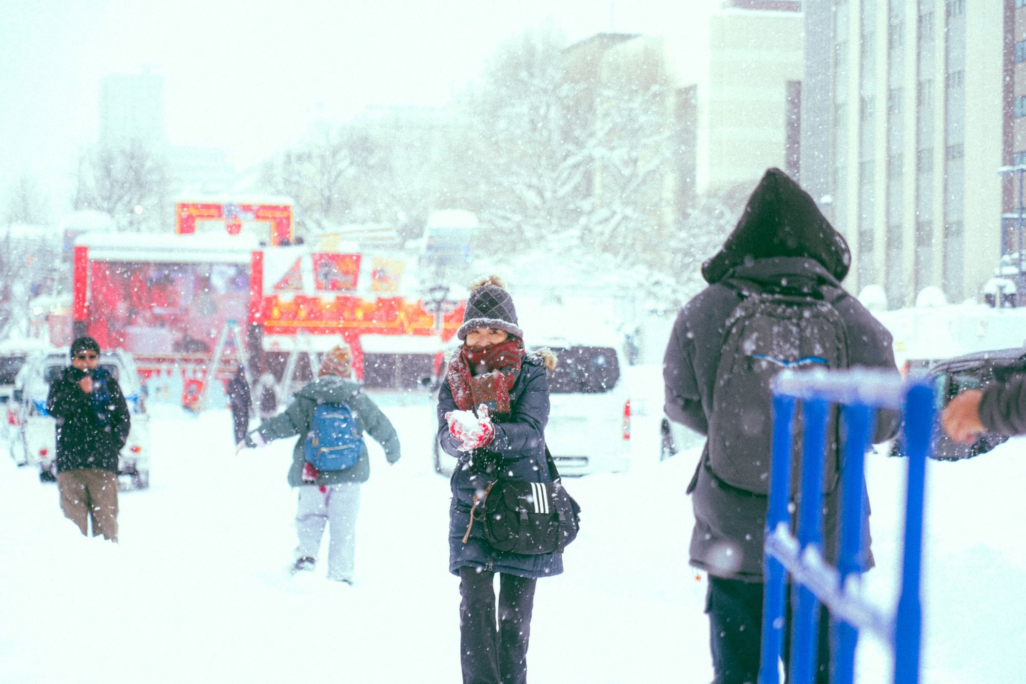 大雪が降る街中を歩く防寒着姿の人たち(イメージ)