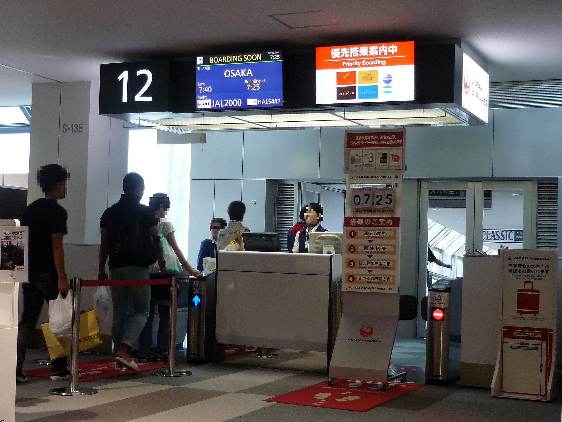 新千歳空港12番搭乗口の案内表示。1つの便に「JAL2000」と「HAL5447」の2つの便名が並んでいる