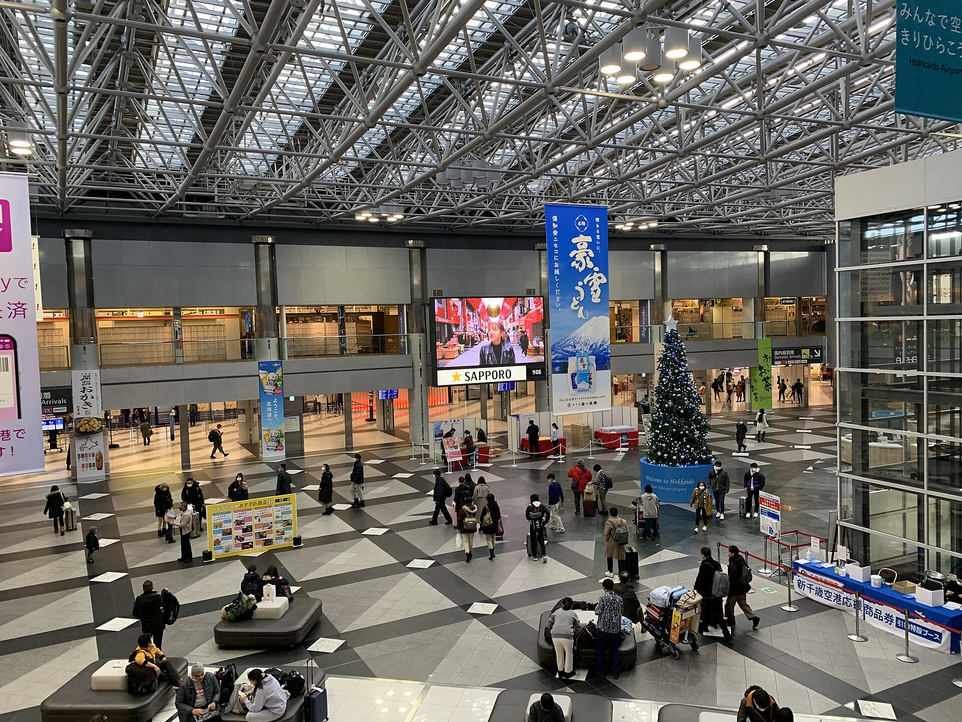 冬の新千歳空港国内線ターミナルの吹き抜けロビーを行き交う旅行者
