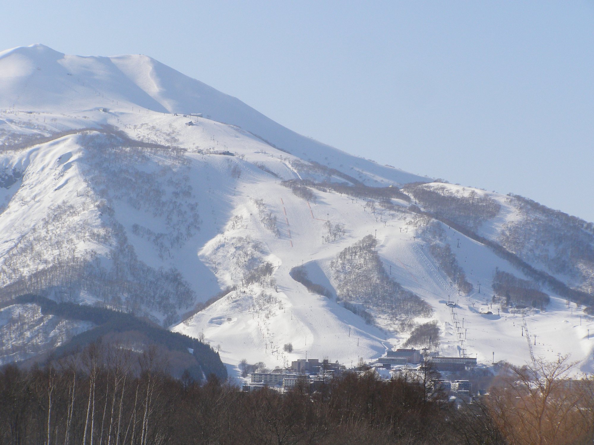 雪に覆われたニセコアンヌプリの斜面に広がるグラン・ヒラフのゲレンデと麓の建物