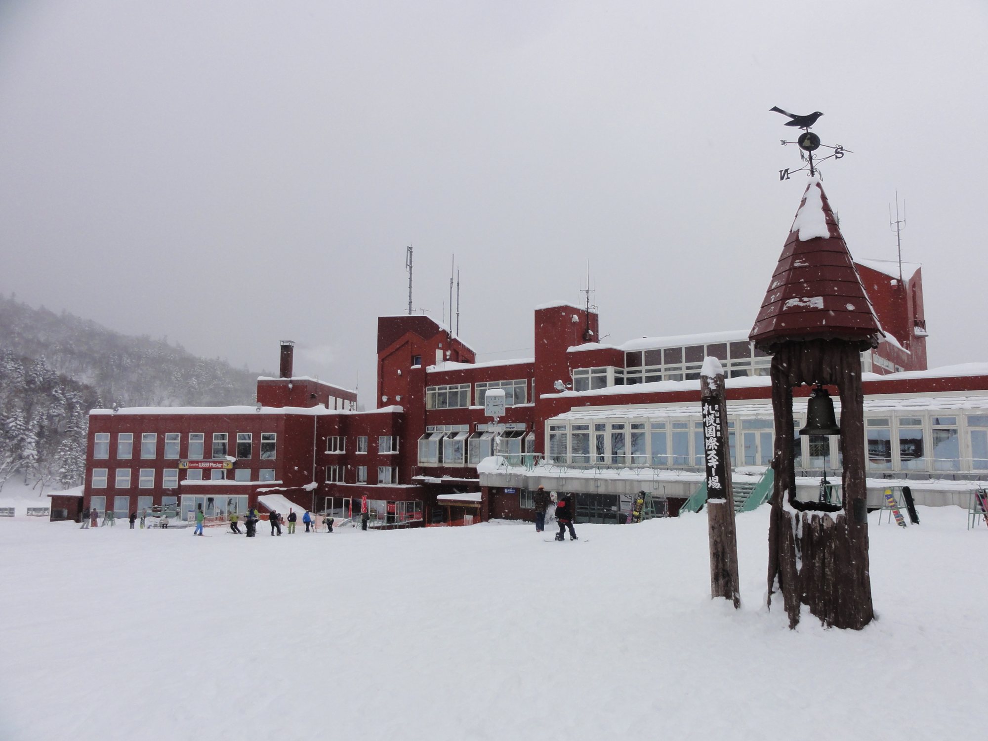 雪が降る中の札幌国際スキー場のゲレンデベースと赤い建物