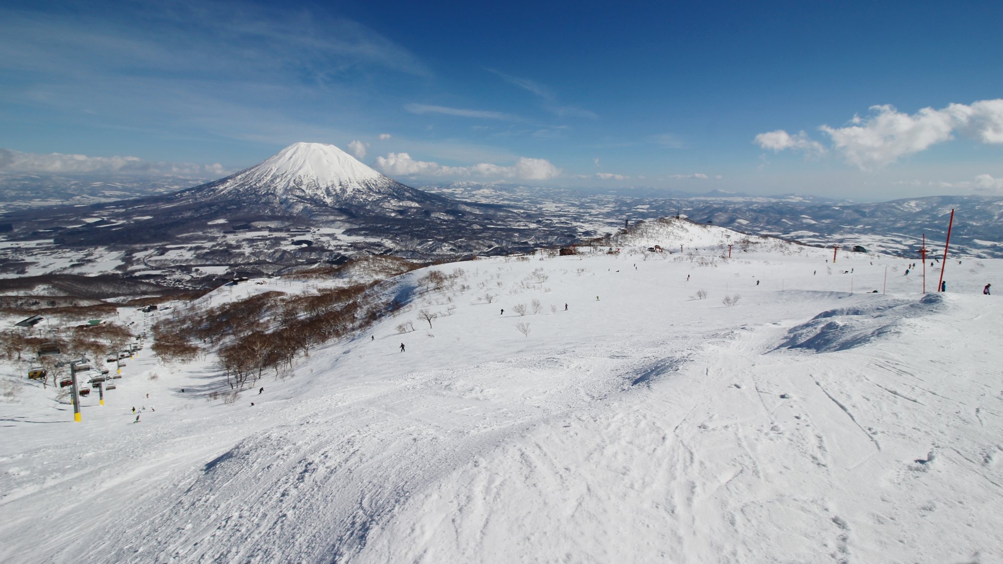 グラン・ヒラフ上部の広い雪原の向こうにそびえる冠雪した羊蹄山