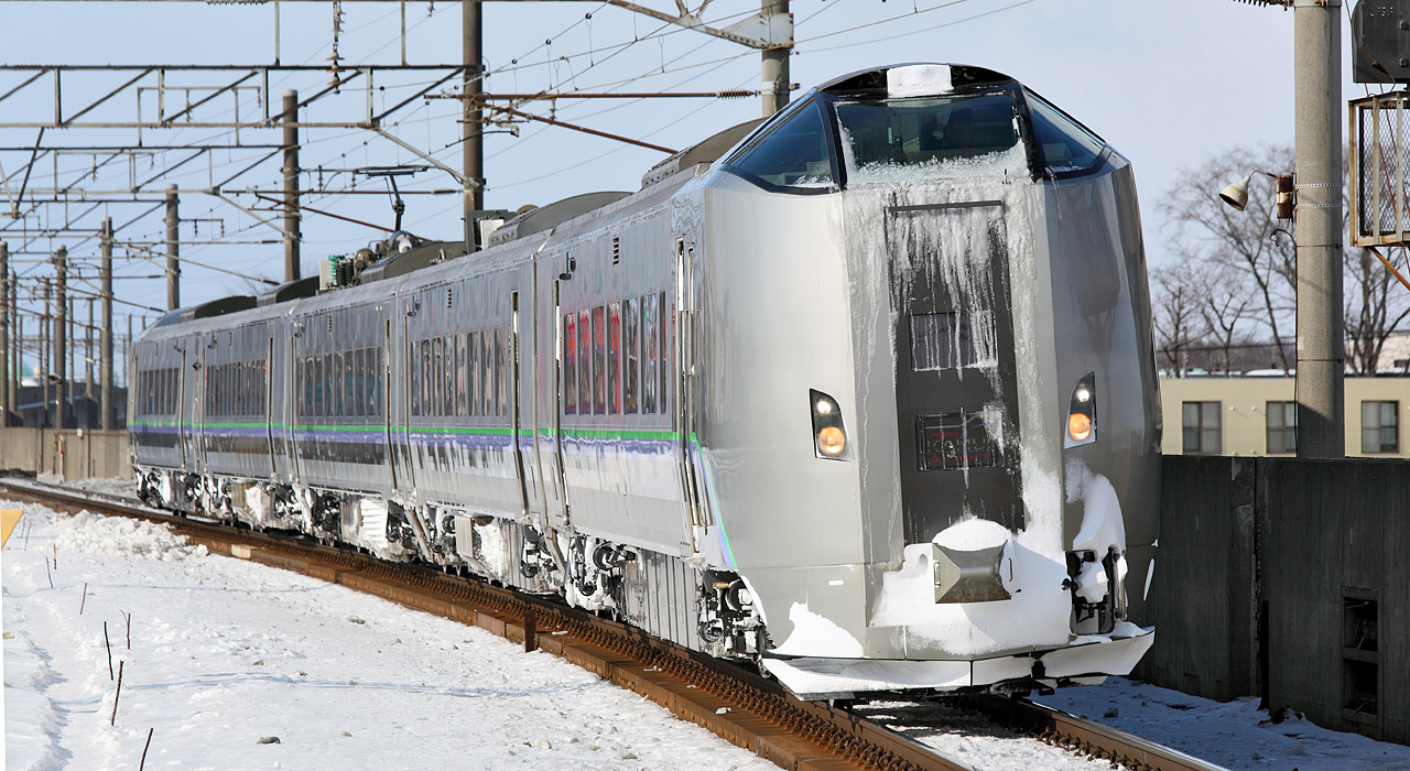 雪の積もった線路を千歳駅へ向かって走る、快速エアポート運用の789系電車