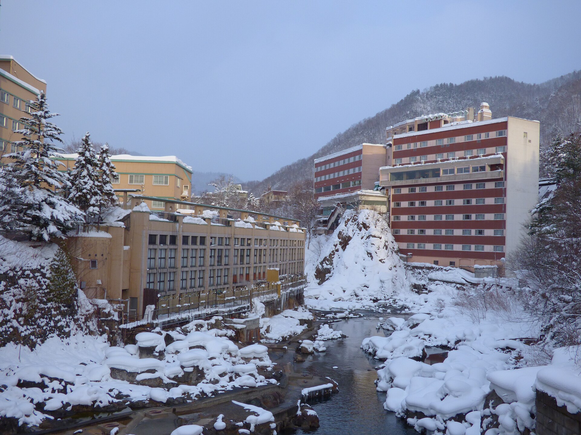雪に覆われた川沿いにホテルや旅館が建ち並ぶ冬の定山渓温泉