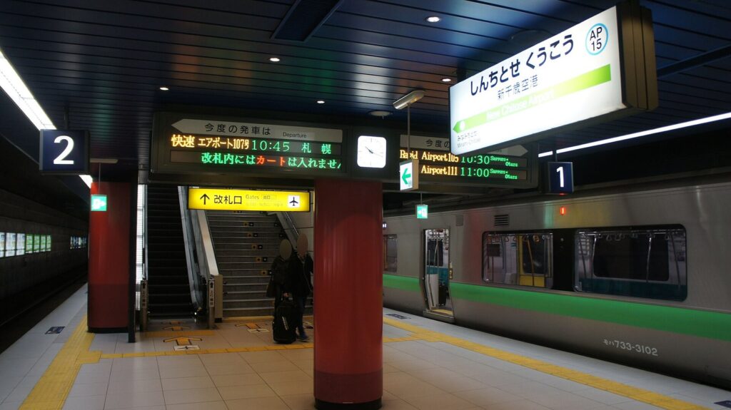 JR新千歳空港駅のホームと、快速エアポートの発車時刻を示す電光掲示板