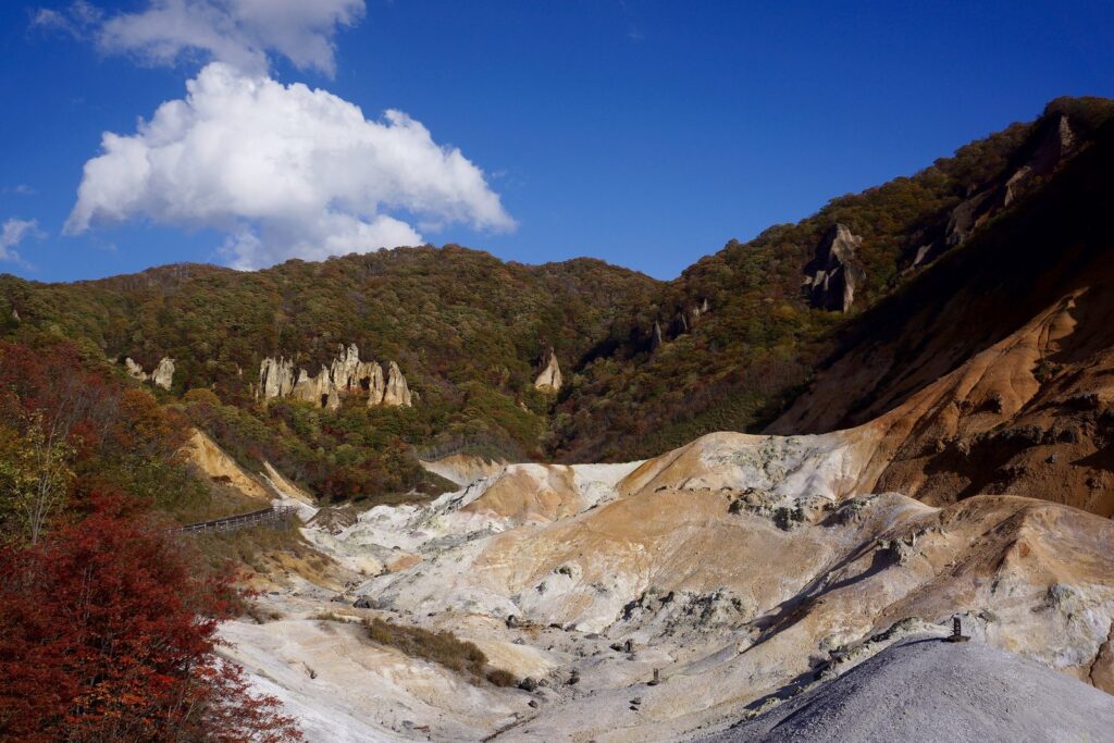紅葉に彩られた斜面と白い岩肌が広がる秋の登別地獄谷