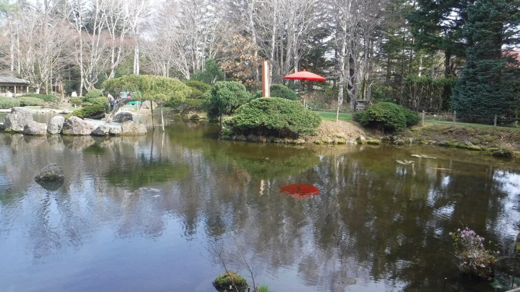 池の周りに木々や石組みを配した真鍋庭園の日本庭園