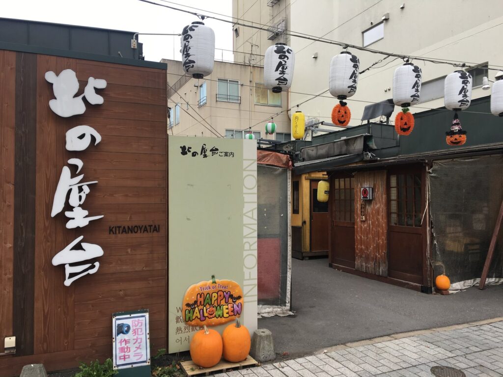 「北の屋台」の看板と提灯が下がる屋台村の入口
