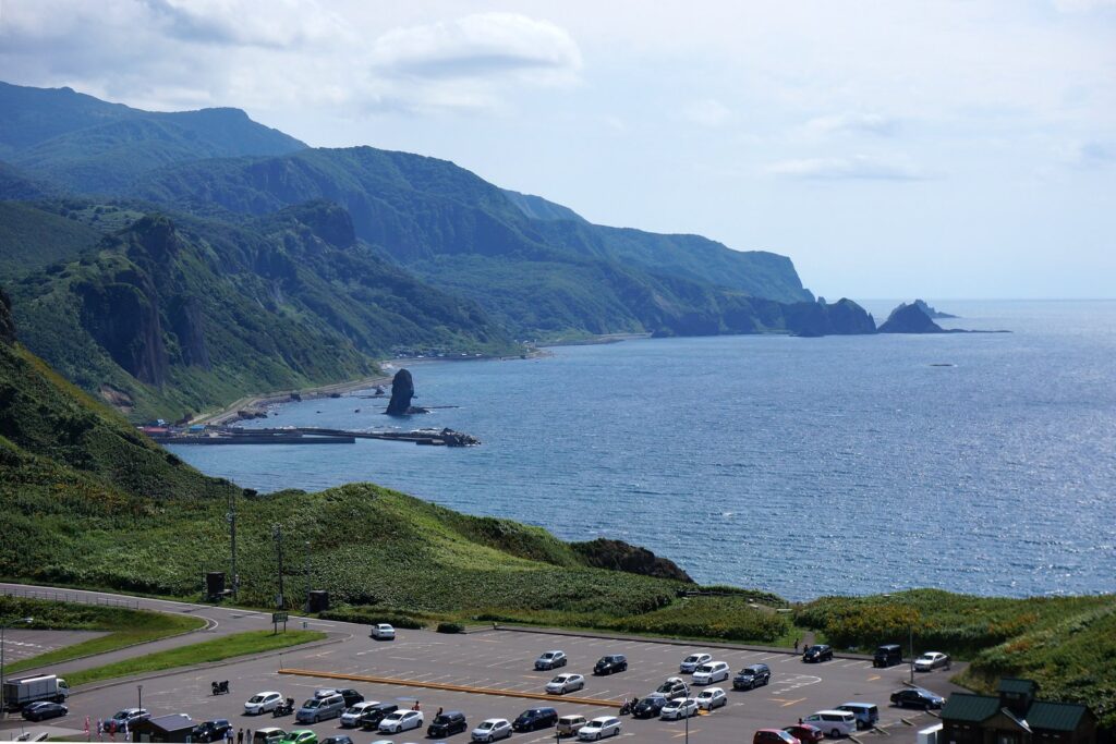 神威岬の高台から南に望む積丹半島の海岸線と、岬の駐車場