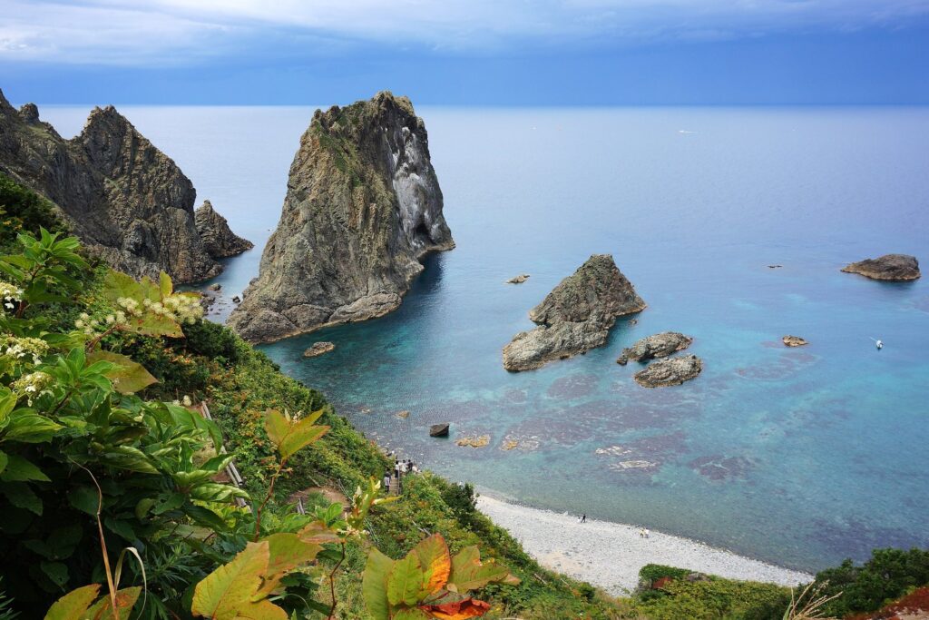 奇岩が点在する島武意海岸の青い入り江と小石の浜