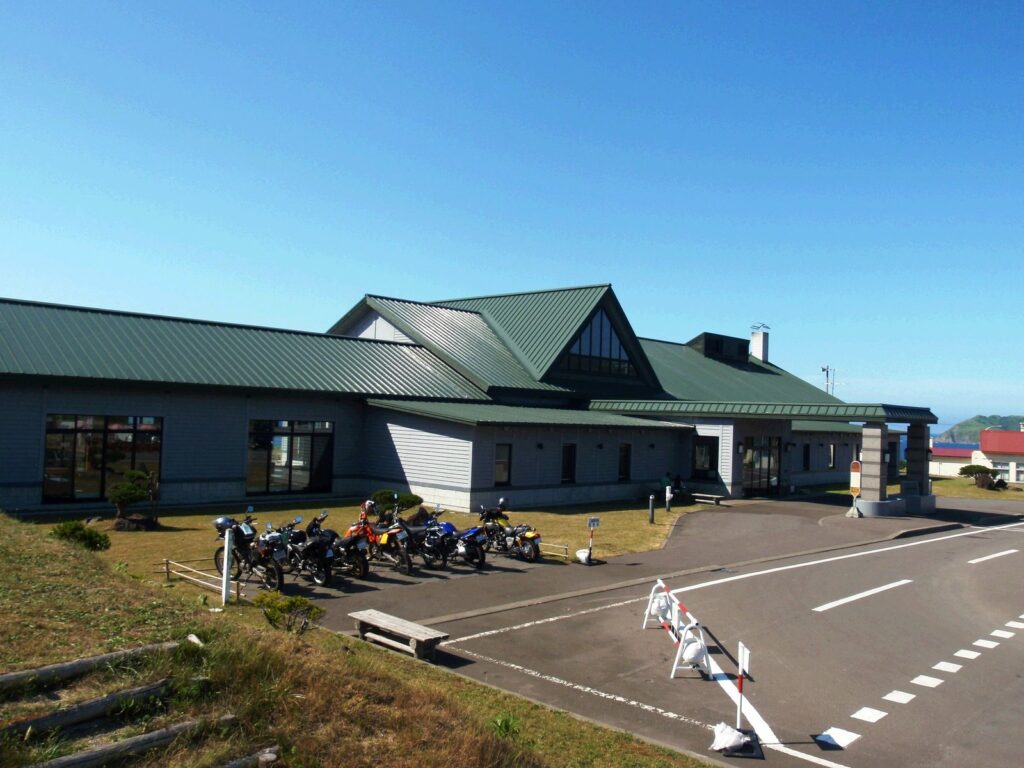 緑の屋根が目を引く岬の湯しゃこたんの建物と駐車場