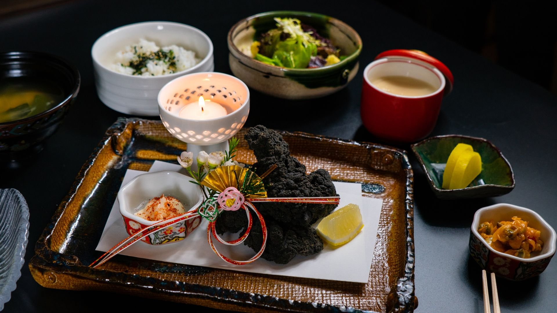 小鉢や焼き物、ろうそくの灯りを並べた和食の膳(イメージ)